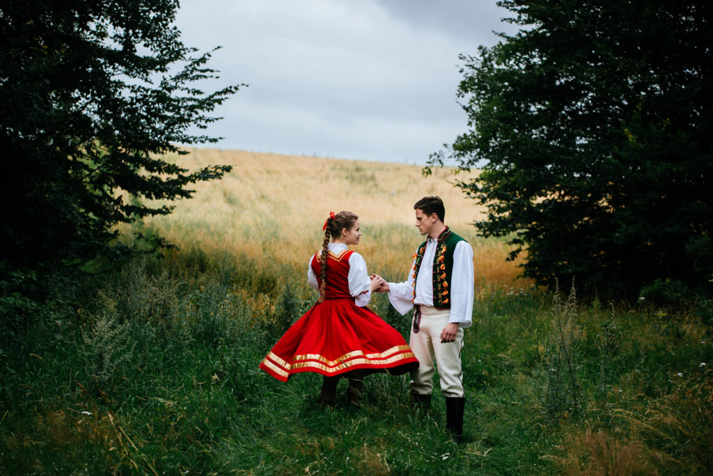Rustykalna sesja ślubna, z użyciem strojów ludowych, zrealizowana w skansenie na Kaszubach, w otoczeniu lasów, łąk i pól. Fot. Rafał i Magda Nitychoruk