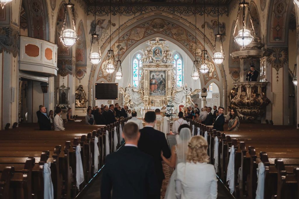 Przebieg ślubu kościelnego w Borach Tucholskich - wejście Pary Młodej wraz z księdzem